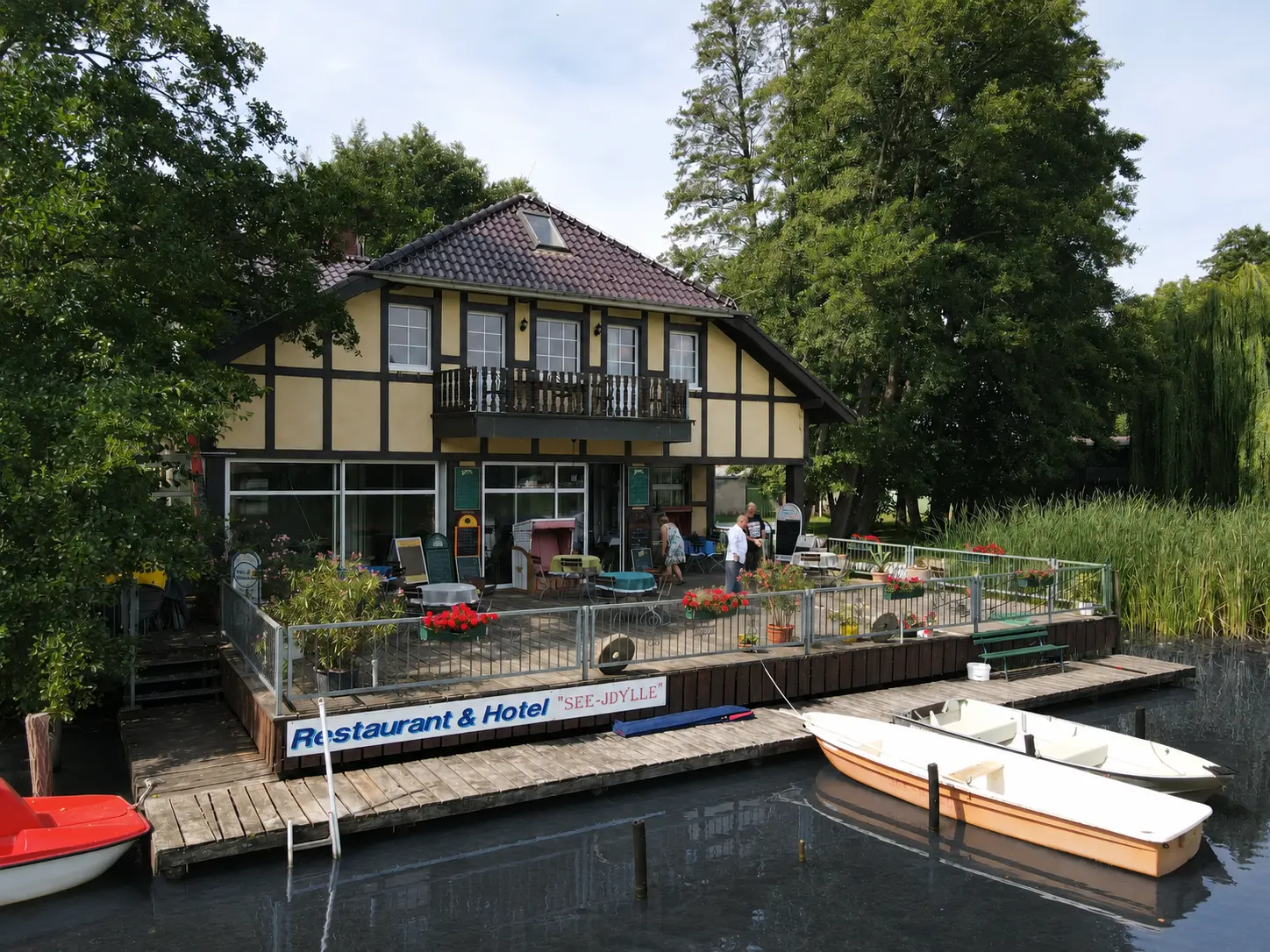 Außenansicht der See-Idylle mit Terrasse und Booten