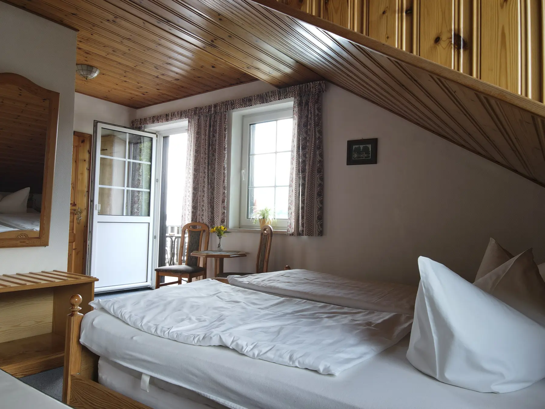 Doppelzimmer mit Balkontür und Blick zum See